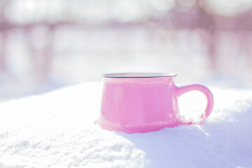 Obraz na płótnie Canvas pink ceramic cup in the snow outdoors