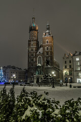 Naklejka premium Winter night in Cracow marketplace, view to St. Mary's Church