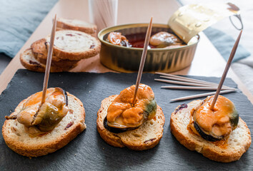 Pickled mussels on a piece of toasted bread with blueberries