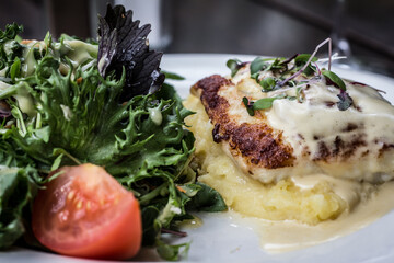 Fresh fish on mashed potatoes with cream and salad
