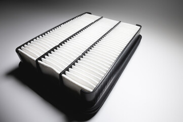 Automotive internal combustion engine filter close-up. Detail of a new car part on gray gradient background