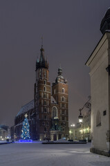 Fototapeta na wymiar Winter night in Cracow marketplace, view to St. Mary's Church