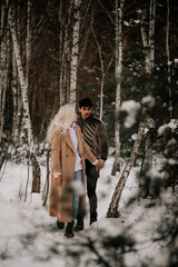 couple walking in winter forest
