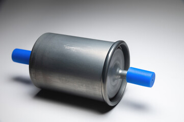 New fuel filter for gasoline internal combustion engine with blue caps on a gray background. New spare parts