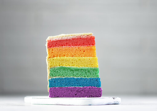 Delicious rainbow cake on wooden board