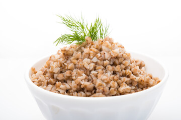 Boiled buckwheat with dill in a plate isolated on a white background