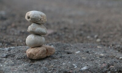 Fototapeta na wymiar Rock stack balance on asphalt. Pile of pebbles. 