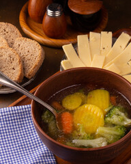 Fresh hot vegetable soup in a ceramic plate on the table