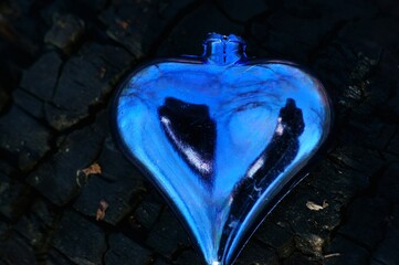 Blue toy heart in the woods. Symbol of love.
