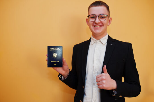 Young handsome man holding Principality of Liechtenstein passport id over yellow background, happy and show thumb up. Travel to Europe country concept.