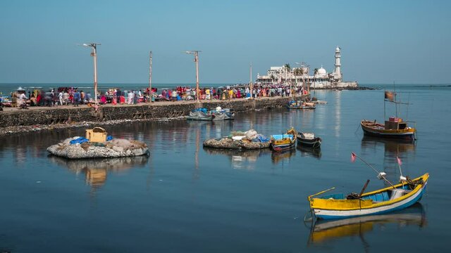 Daytime time lapse view of worshippers at historical landmark Haji Ali Dargah mosque in Mumbai, Maharashtra, India.