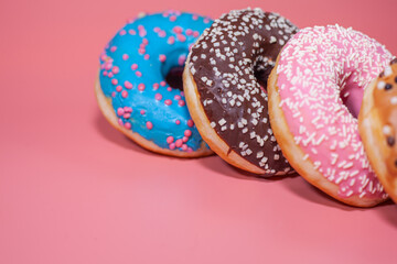 Sweet delicious donuts on a pink background