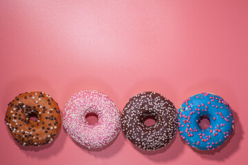Sweet delicious donuts on a pink background