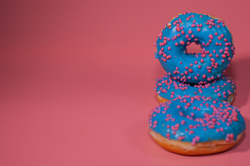 Sweet delicious donuts on a pink background