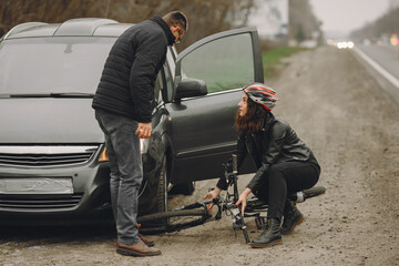 Obraz premium The woman crashed into the car. Girl in a helmet.