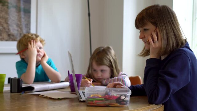 Mum teaching her two kids from home whilst working herself