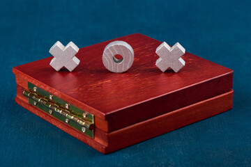 Game Tic Tac Toe, game tokens on a wooden box close-up, shallow depth of sharpness