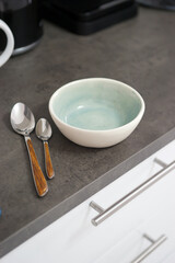 Empty bowl and two spoons on the table in the kitchen