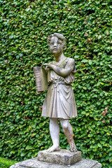 Fototapeta premium Statue of a boy with a book in the park.