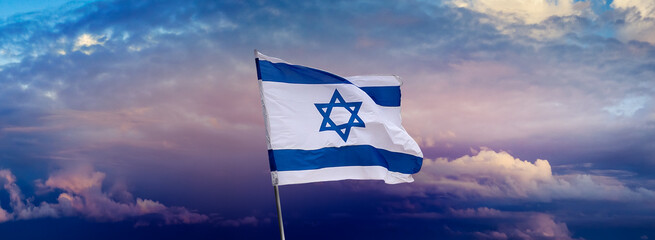 Israeli flag with a star of David over Jerusalem at cloudy sky background on sunset, panoramic view. - 407513257