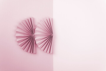 Origami flowers on pale pink paper. Abstract origami background. Texture banner background. Greeting card concept. Flat lay.