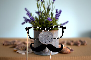 A comical can full of flowers dressed with funny accessories