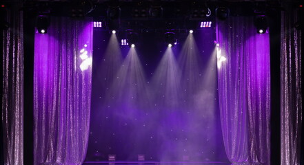 An empty stage of the theater, lit by spotlights and smoke before the performance	