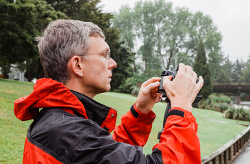 Mature man looking at his camcorder