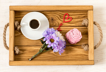 Aromatic coffee with dessert and a small bouquet. Flat lay on festive frame