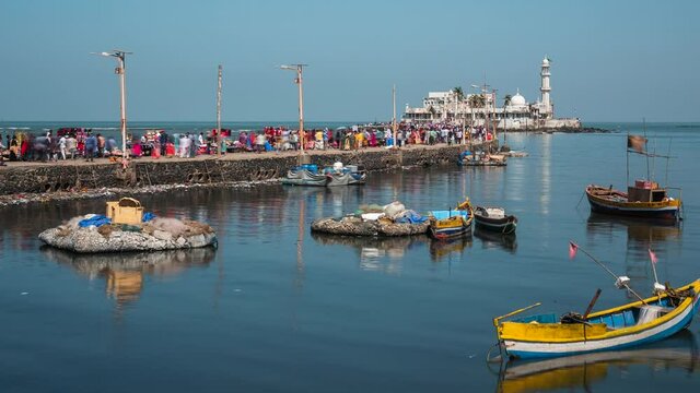 Mumbai, India, zoom out time lapse view of worshippers at historical landmark Haji Ali Dargah mosque.