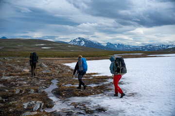 Hiking Trails leading away from Camera with group of hikers on snow