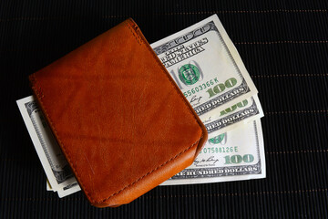 Dollars in a leather wallet.