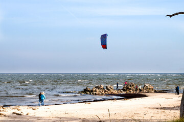 Obraz premium A bright sail in the sky for kateboarding on the waves. Active and extreme sports.kiteboarding in the Gulf of Riga in October 2019 at Cape Kolka in Latvia.