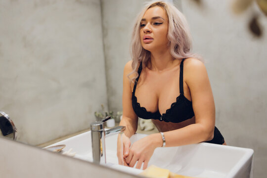 beautiful brunette woman in bikini sitting under shower. Perfect body.