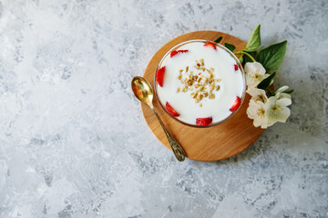 Healthy breakfast of strawberry parfait with fresh fruit and yogurt on a gray table.Oatmeal dessert...