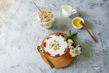 Oatmeal dessert with fresh strawberries. Healthy breakfast of strawberry parfait with fresh fruit and yogurt on a gray table. Panna Cotta. Correct, natural nutrition. Space for text. Still life