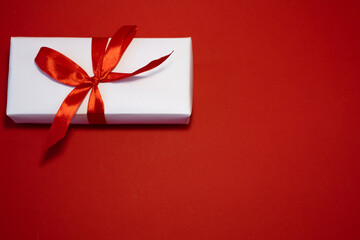 Banner. Velentin Day. White handmade gift boxes with red ribbon on a red background. Copy space. Holidays and love concept