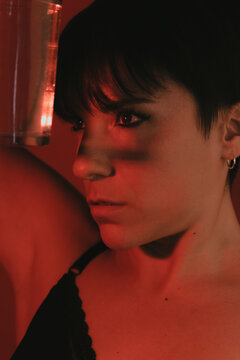 Portrait of a woman looking at a glass of water in studio