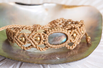 Waxed string made labradorite stone beige bracelet on natural neutral background