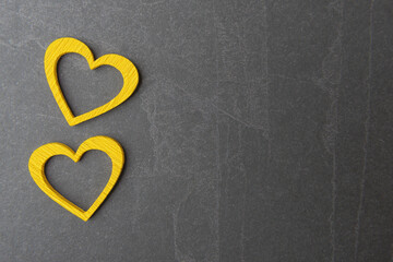Two yellow Valentine’s hearts on grey stone background with copy space. Valentines day concept