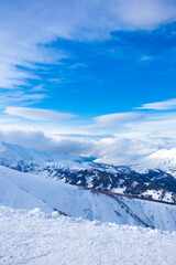 Fototapeta premium Snow peaks of mountains with blue sky and beautiful clouds. Winter tourism in Russia, Arkhyz. Snow valley on horisontal landscape.