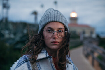 Cinematic portrait of beautiful moody young woman in her 20s or teenager. Millennial woman look at camera, candid portrait of authentic woman with serious face expression. Pretty generation z face