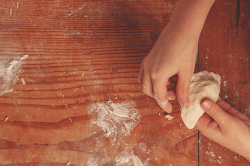 Top view of beautiful young girl making homemade dumplings. Dumplings with potatoes and cheese stuffing. Free copy space for design.