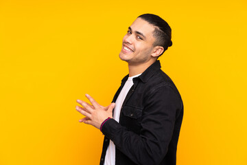 Asian handsome man isolated on yellow background frustrated and covering ears