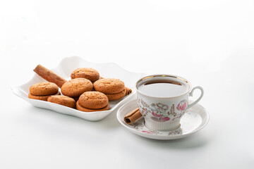 cup of hot tea cinnamon cookies selective focus on white background high key