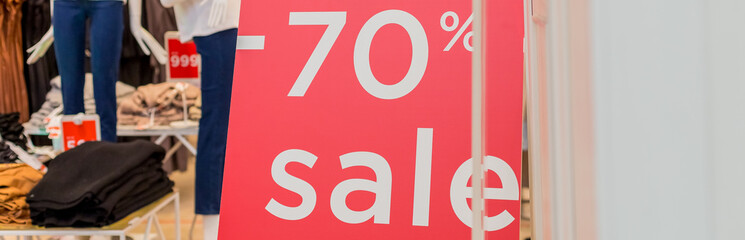 Sale up to 70 percent red sign. Red display with sale up to seventy percent inscription sticked on the store window.Seasonal discounts in stores, sale, Black Friday and shopping concept.