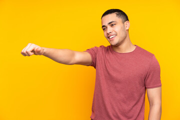 Asian handsome man isolated on yellow background with an expression of frustration and not...