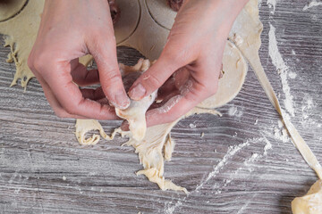 woman hands are making a dumpling on wooden table