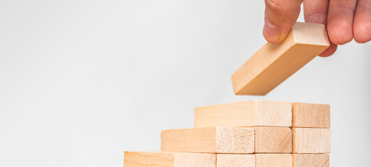 Businessman stacking wooden blocks. Hand arranging wood block stacking as step stair. Ladder career...