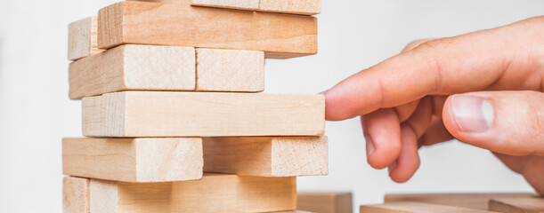 Planning, risk and strategy in business, businessman gambling placing wooden block on a tower. The...